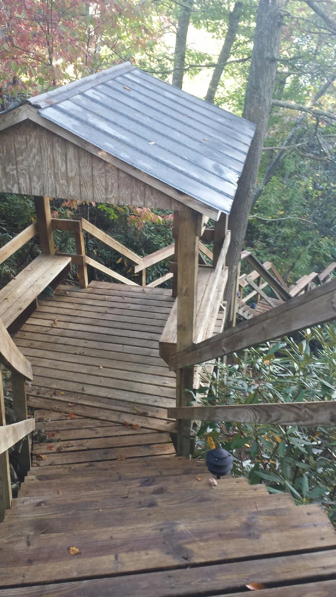 Metal roofed shelter over wooden steps on a wooded walkway — Skylight Repair & Installation work by our crew in New York