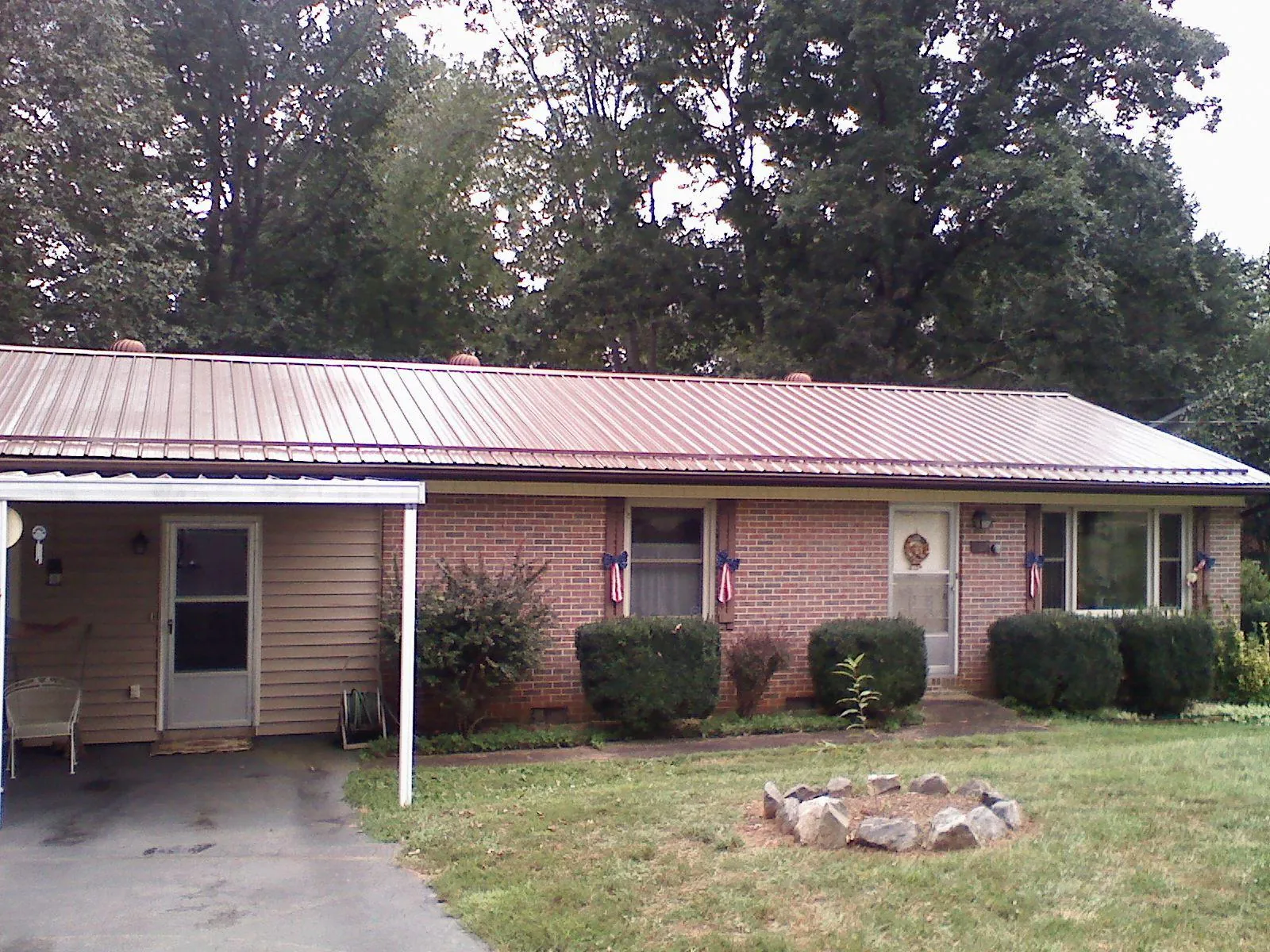 Bronze metal roof and carport on a brick ranch home — Roof Repair work by our crew in New York
